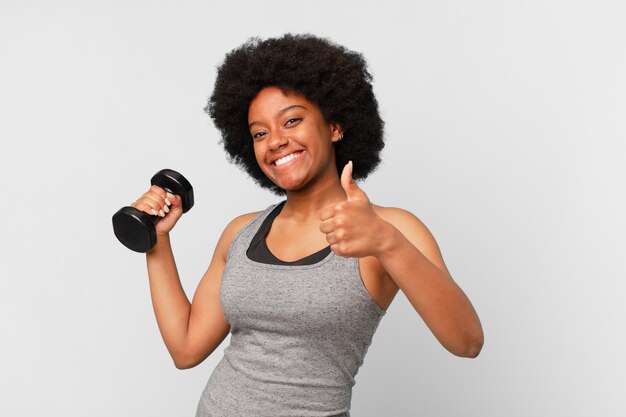 Mujer fitness afro negro con una mancuerna