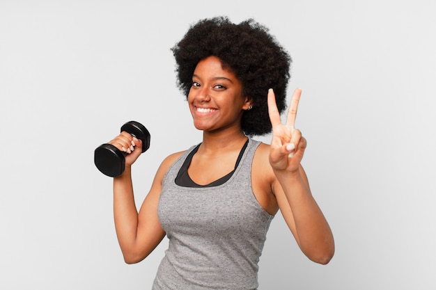 Mujer fitness afro negro con una mancuerna