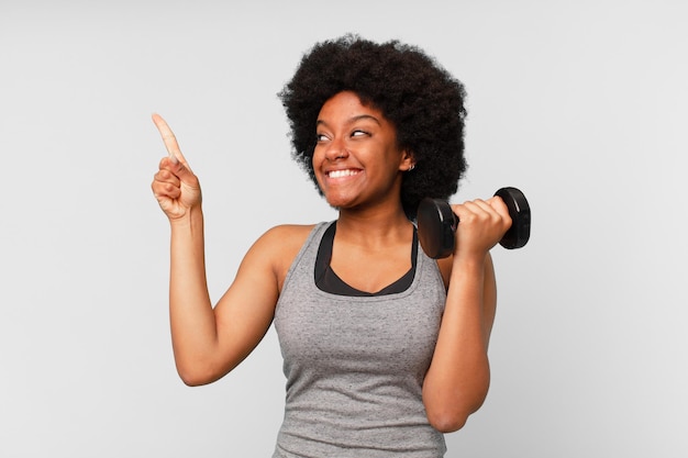 Mujer de fitness afro negro con una mancuerna