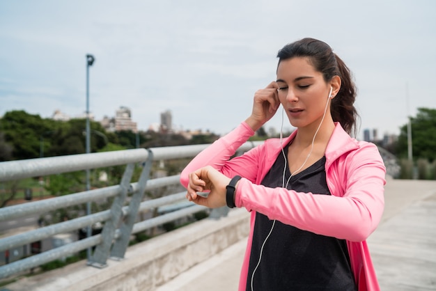 Mujer fitness control de tiempo en reloj inteligente.