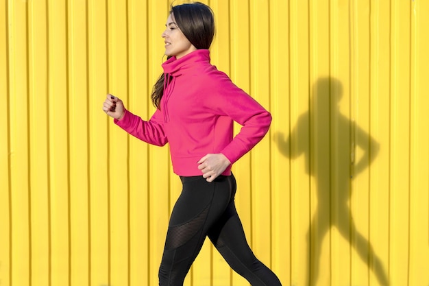 La mujer fitness corre al aire libre en un entorno urbano