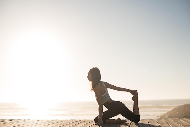 Mujer fitness disfrutando de la hermosa puesta de sol en la playa