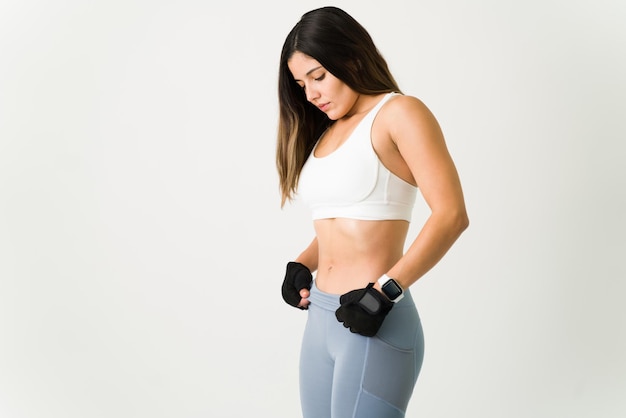 Mujer fitness entrenando para tener un abdomen fuerte y mostrando su núcleo tonificado. Joven atleta con ropa deportiva trabajando sus abdominales