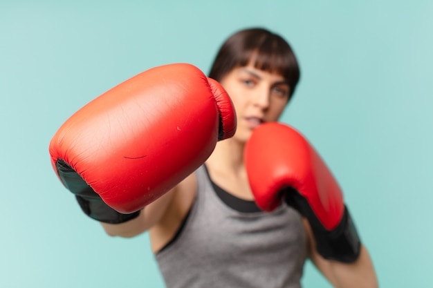 Mujer fitness con guantes de boxeo rojos.