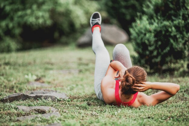 Mujer fitness haciendo ejercicio al aire libre en el parque.