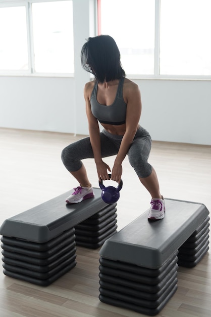 Mujer fitness haciendo ejercicio con Kettle Bell