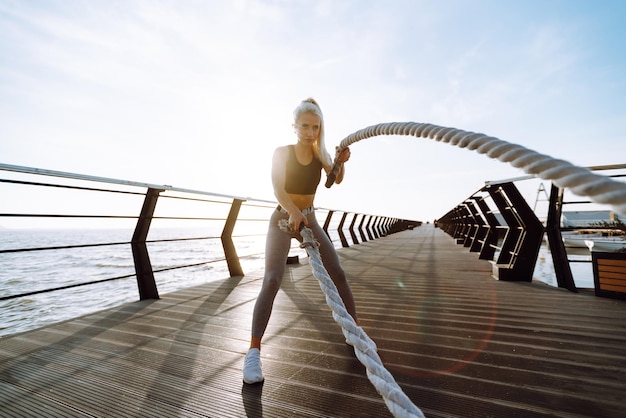 Mujer fitness haciendo ejercicios deportivos en el muelle de la playa Estilo de vida saludable Deporte Vida activa