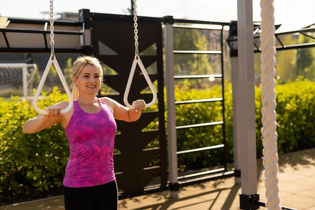 Mujer fitness haciendo sentadillas en el gimnasio al aire libre haciendo entrenamiento de fuerza