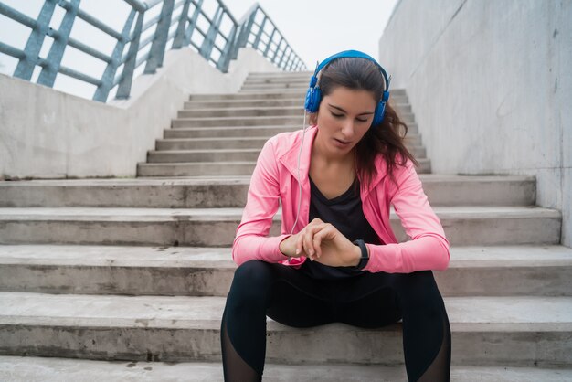 Mujer fitness monitoreando su progreso en smartwatch.