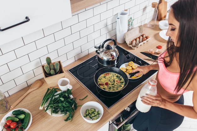 Mujer fitness preparar desayuno saludable avena casera con verduras