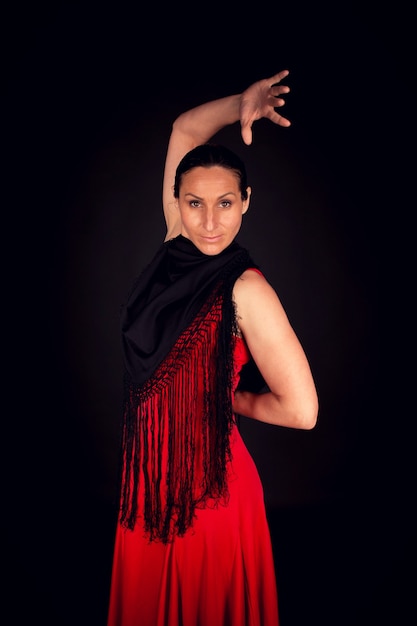 Mujer flamenca en vestido rojo con una mano hacia arriba