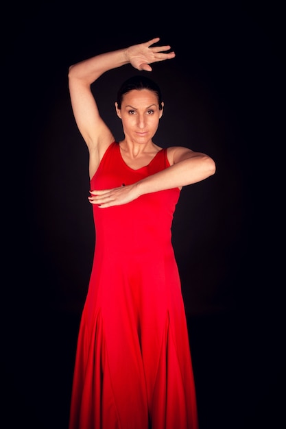 Mujer flamenca con vestido rojo con la mano levantada