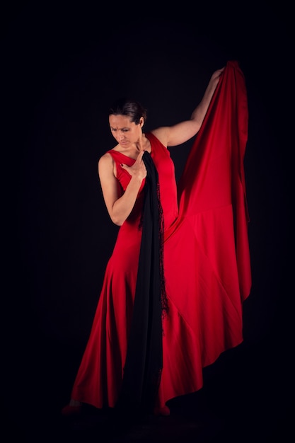 Mujer flamenca en vestido rojo y mirando al suelo