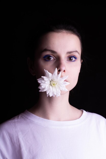 mujer con flor blanca fondo negro