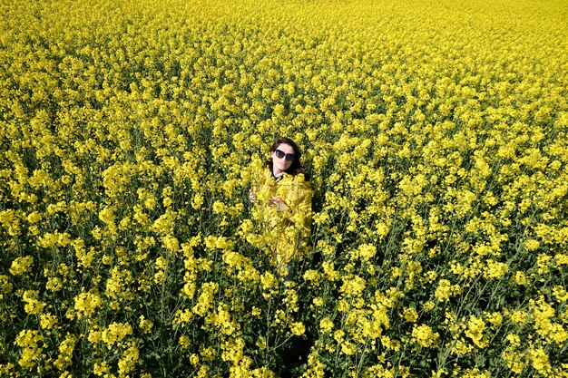 Mujer y flores amarillas de colza