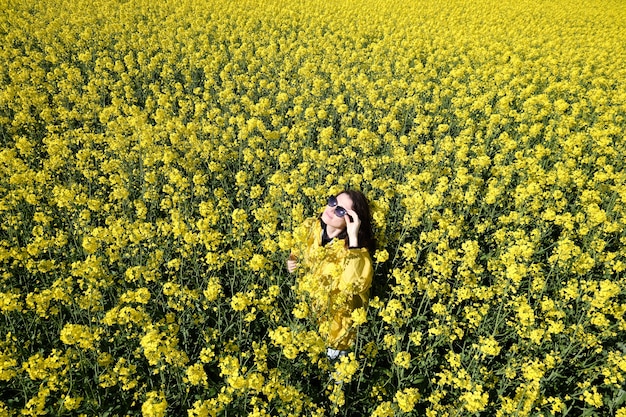 Mujer y flores amarillas de colza