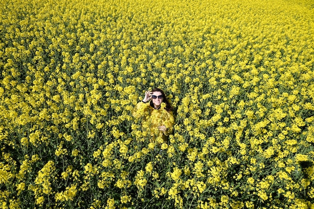 Mujer y flores amarillas de colza