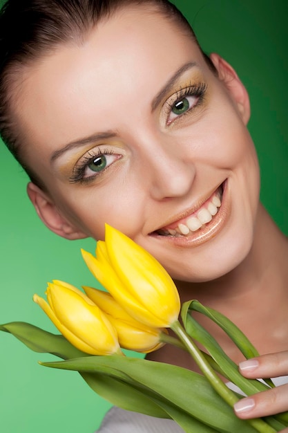 Mujer con flores amarillas sobre fondo verde