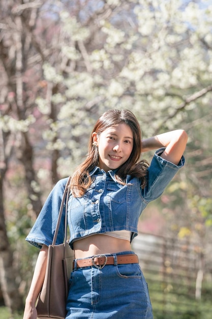 Mujer con flores de cerezo o flor de sakura que florece en el parque