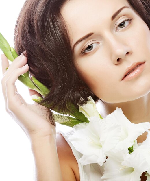 Mujer con flores de gladiolo en la mano