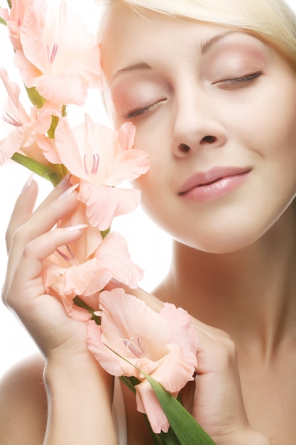 Mujer con flores de gladiolo en sus manos