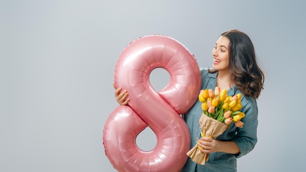 mujer con flores y globo en forma de ocho