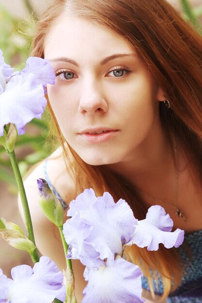 Mujer con flores posando en el parque de verano