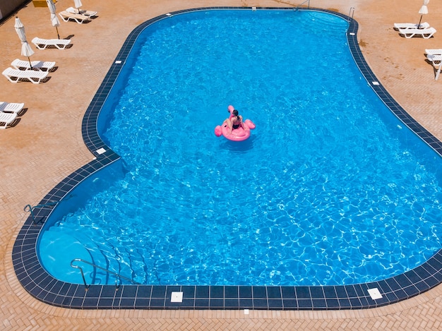 Mujer, flotar, en, piscina, flamingo, flotador, en, piscina, en, hotel