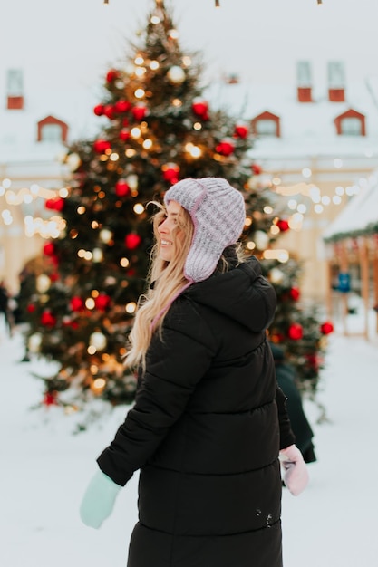 mujer en el fondo de un árbol de navidad en invierno