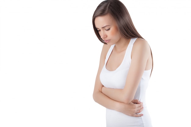 Mujer en el fondo blanco aislado que tiene dolor de cabeza o de estómago. Primer plano femenino sentirse enfermo. Lady siente dolor.