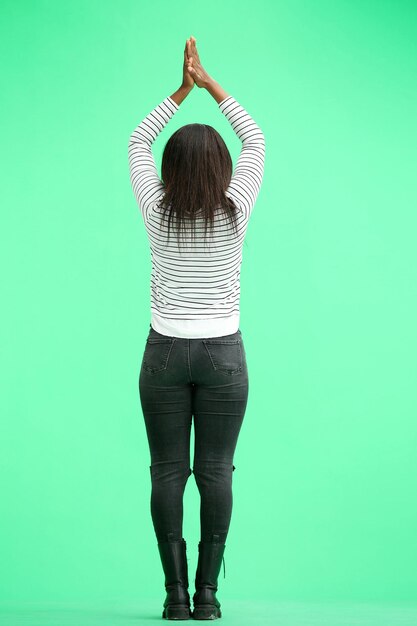 Una mujer en un fondo verde en pleno aplausos de altura