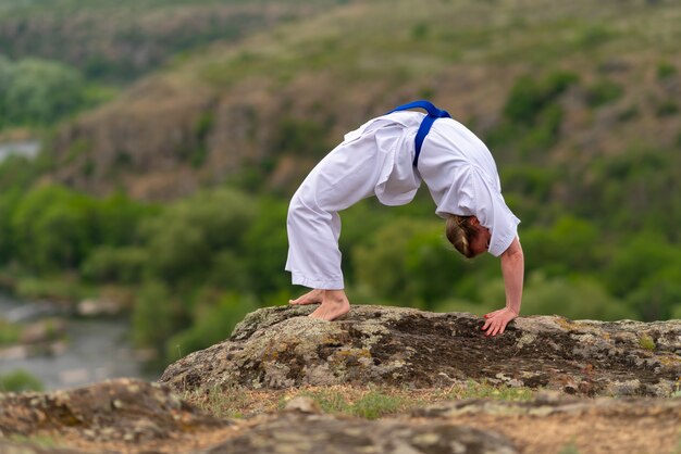 Mujer en forma flexible haciendo un estiramiento hacia atrás al aire libre para aumentar la flexibilidad