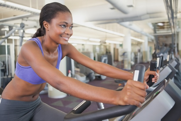 Mujer en forma haciendo ejercicio en la bicicleta de ejercicio