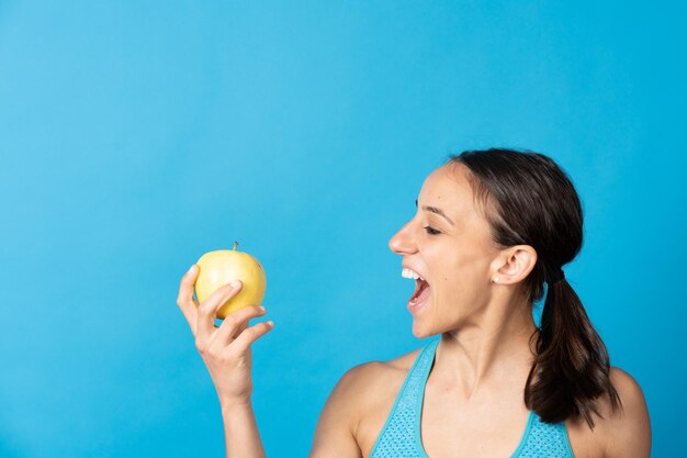 Mujer en forma hispana mirando apple