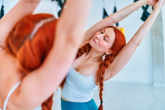 Foto mujer en forma practica ejercicios de estiramiento de la espalda y calienta los músculos en la clase de yoga en el estudio