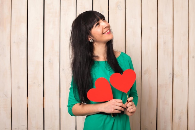 Mujer con forma roja de corazón en vestido verde en el día de San Valentín
