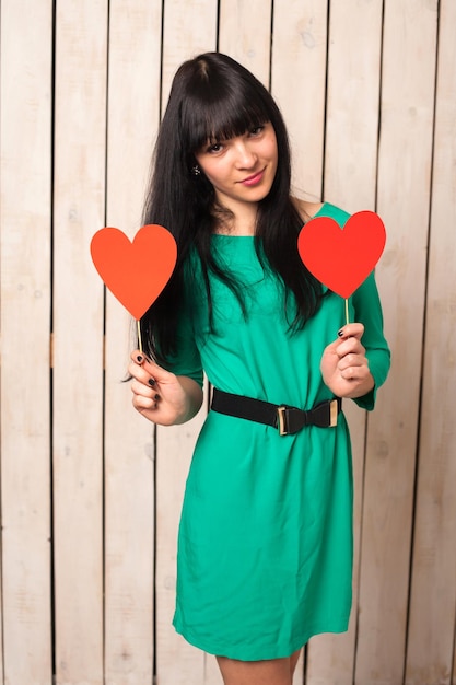 Mujer con forma roja de corazón en vestido verde en el día de San Valentín