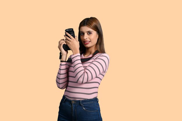 mujer fotógrafa sonriendo y sosteniendo cámara modelo pakistaní indio