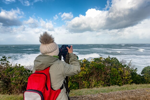 Mujer fotógrafa trabajando durante una tormenta en Biarritz Francia