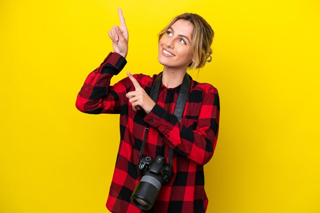 Mujer fotógrafa uruguaya aislada de fondo amarillo señalando con el dedo índice una gran idea