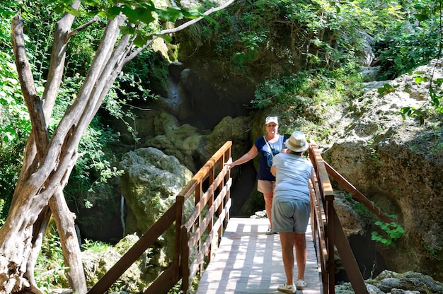 Una mujer fotografía a otra mujer contra el telón de fondo de las rocas.