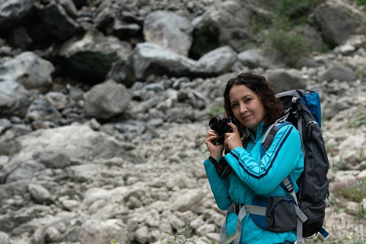 Una mujer fotografía el paisaje en las montañas.