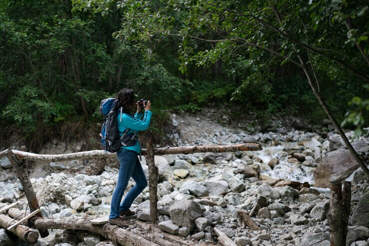 Una mujer fotografía un río en las montañas del norte del Cáucaso.