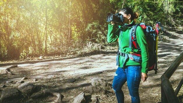 Foto mujer fotografiando en el bosque