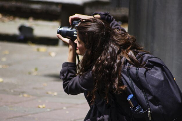 Foto mujer fotografiando con una cámara