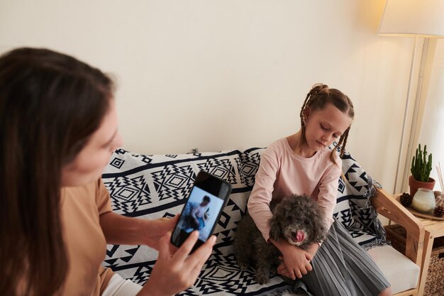 mujer fotografiando hija con perro