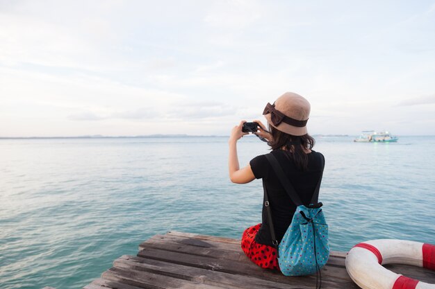 Foto mujer fotografiando el mar