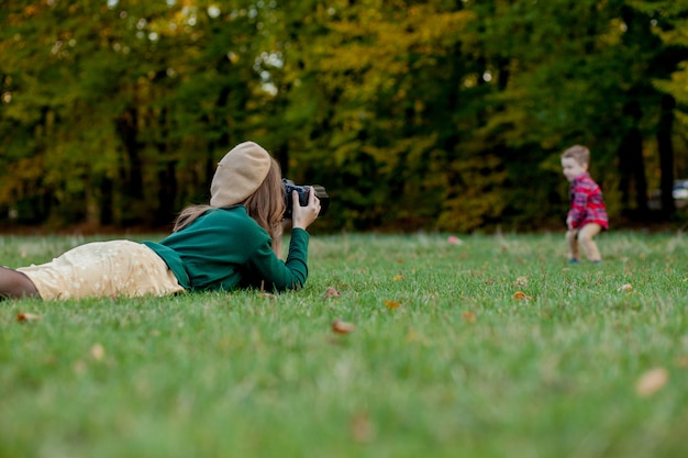 Mujer fotografiando a un niño pequeño