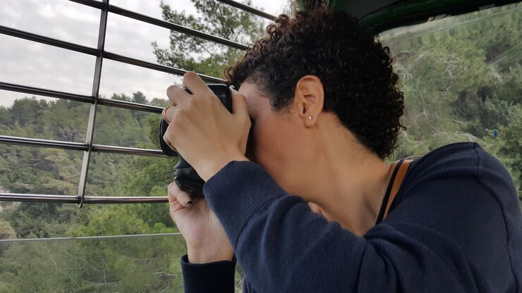 Foto mujer fotografiando en la ventana