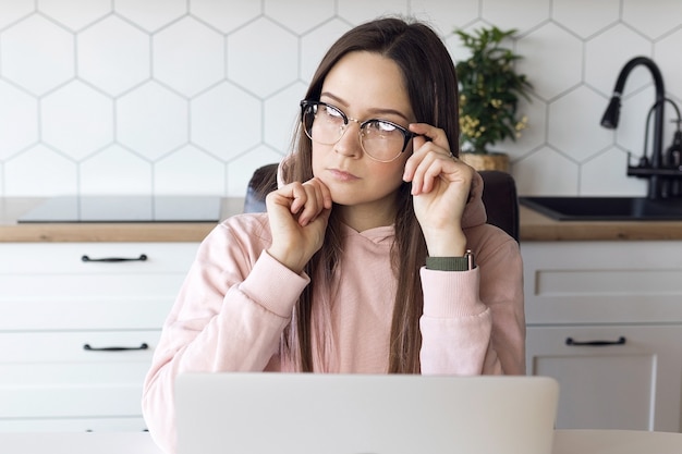 Mujer freelance con gafas concentrarse trabajando en equipo portátil